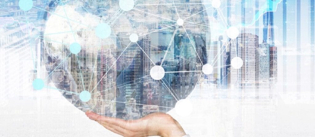 A hand holds a transparent globe with a network of white connected dots overlaid, set against a cityscape background, symbolizing global connectivity and technology integration.