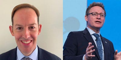 Two men wearing suits; the man on the left is smiling at the camera against a light background, while the man on the right is speaking and gesturing with his hands in front of a blue background.
