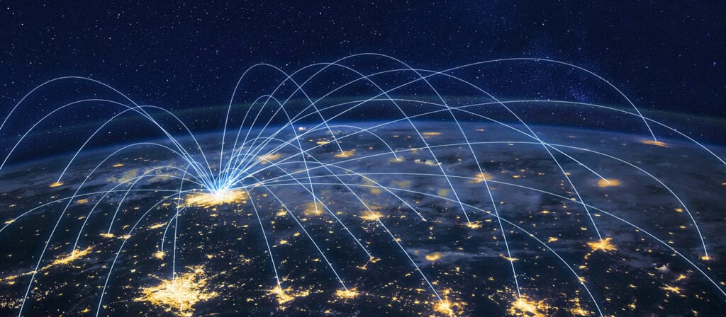 A view of Earth from space at night, with glowing city lights and curved blue lines connecting various points, symbolizing global communication or data networks.