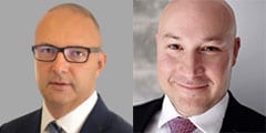 Two men in business attire are shown side by side. The man on the left has glasses and a shaved head, wearing a suit and tie. The man on the right is also bald, smiling, and dressed in a suit and tie.