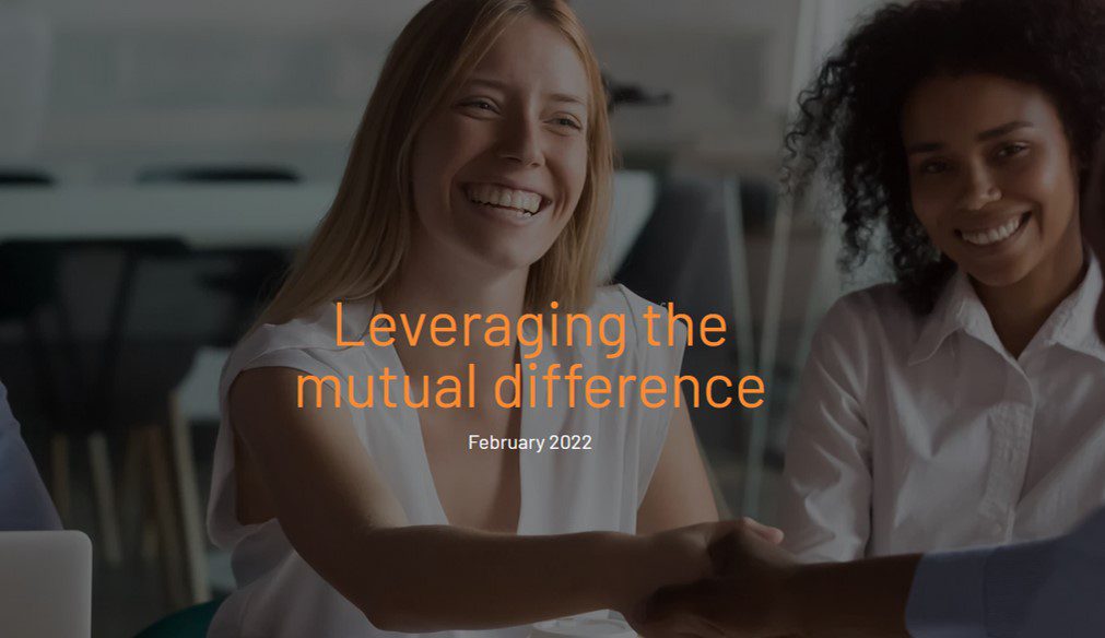 Two women smiling and shaking hands in an office setting. Overlaid text reads Leveraging the mutual difference, February 2022.