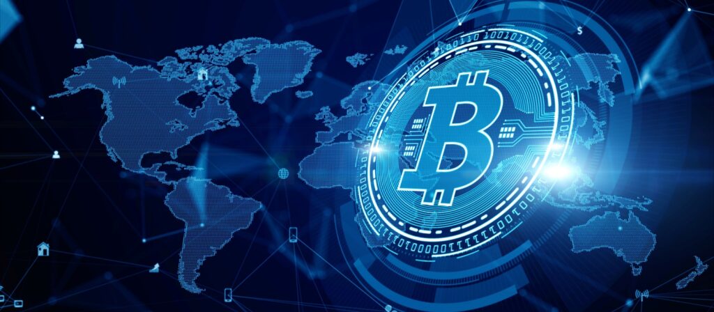 A glowing digital Bitcoin symbol hovers over a blue world map, with interconnected lines and network icons, representing global cryptocurrency and blockchain technology.