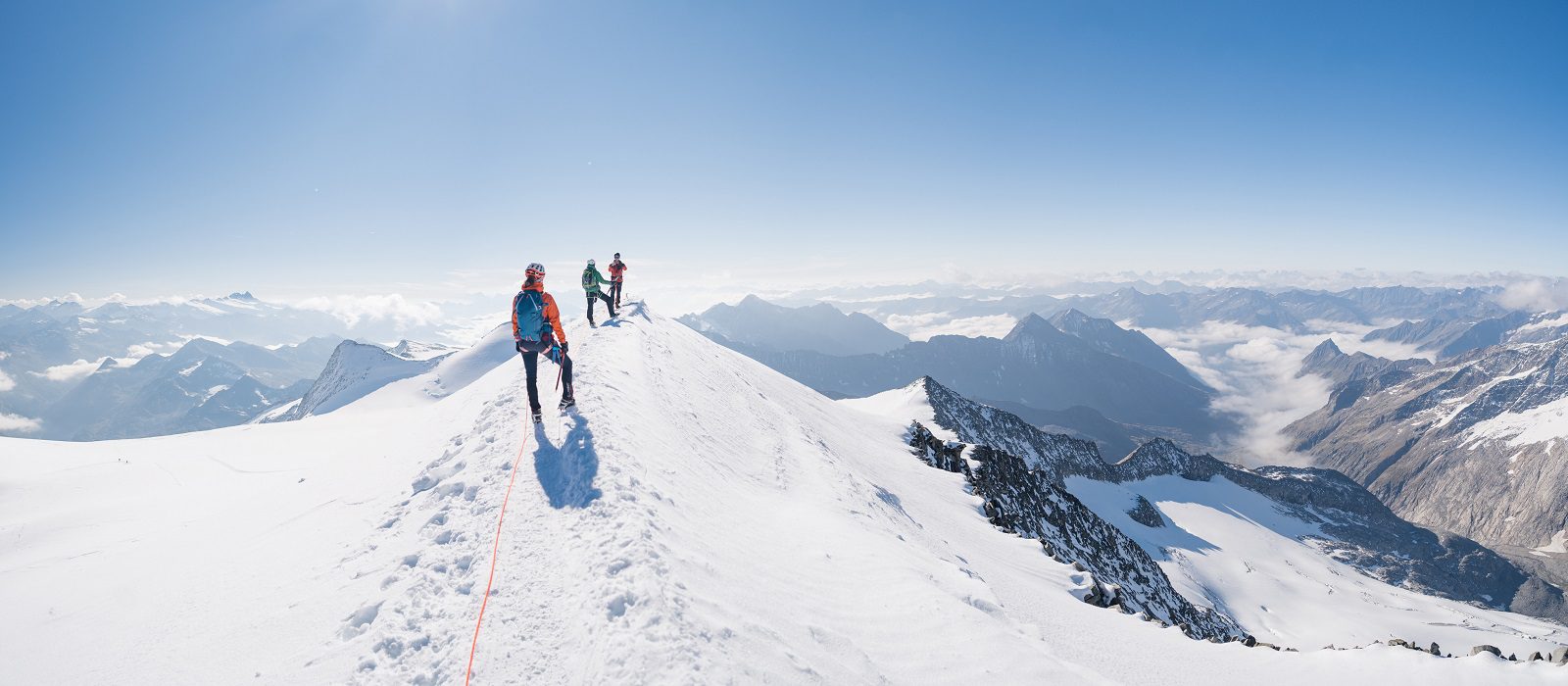 Climbers team on a trail through a dangerous glacier and avalanc