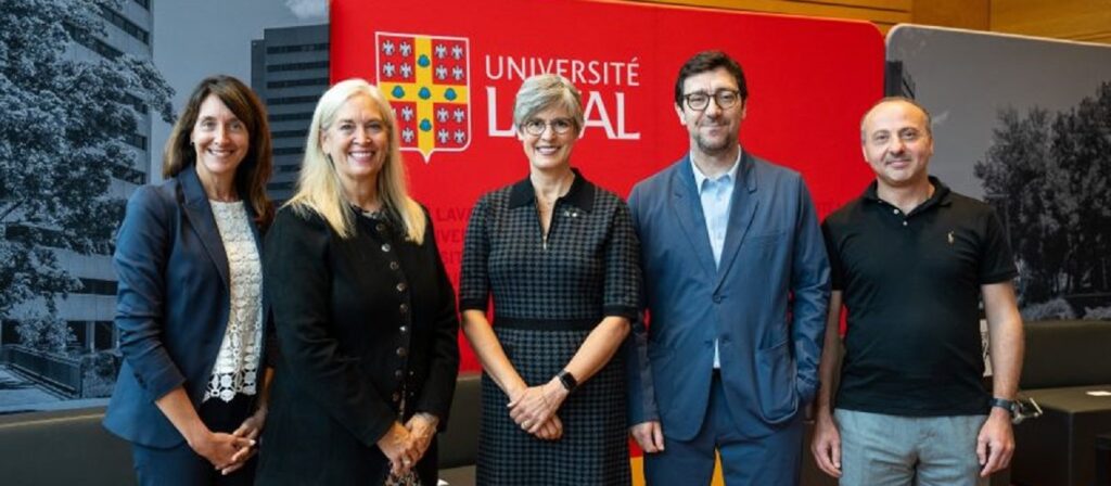 Five people stand in front of a red Université Laval backdrop, smiling at the camera; three women are on the left and two men are on the right, all in business or smart casual attire.