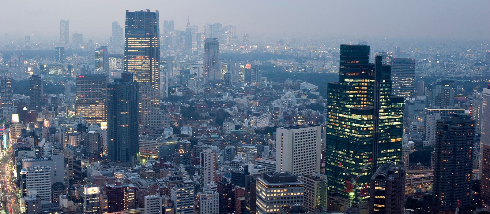 a grey looking urban scene, office buildings in tokyo with their lights on