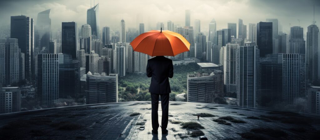 A person in a suit stands on a rooftop, holding an orange umbrella, overlooking a modern city skyline shrouded in clouds and mist, with greenery visible among the tall buildings.