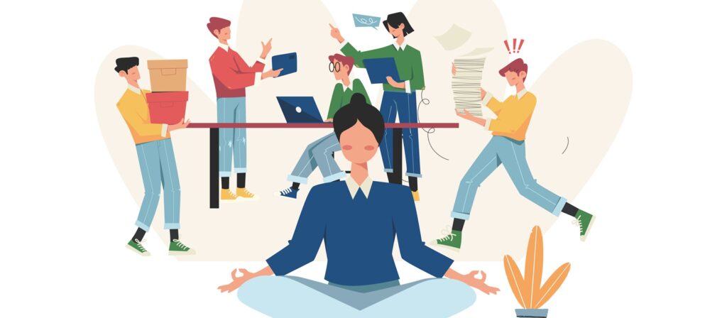 A woman practices meditation in the foreground while four busy coworkers behind her handle files, paperwork, and laptops, depicting a contrast between calmness and a hectic work environment.