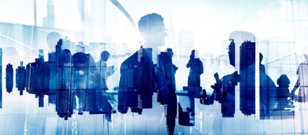 Silhouettes of business people interacting and networking, overlaid with a cityscape background, suggesting a professional urban environment and corporate collaboration.