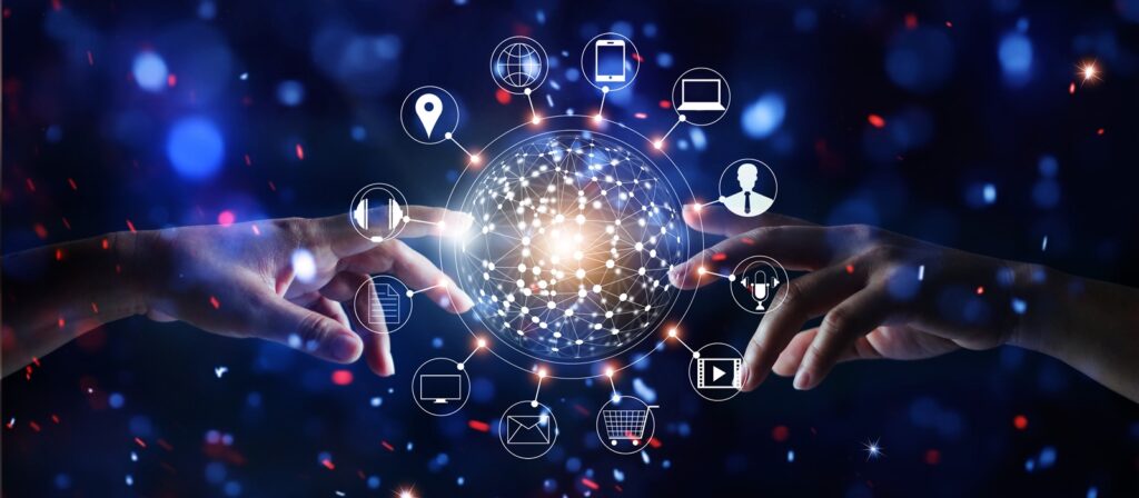 Two hands reach towards a glowing, networked digital sphere surrounded by technology icons such as email, shopping trolley, trophy, and globe, symbolising digital connectivity and communication, with a blue, abstract background.
