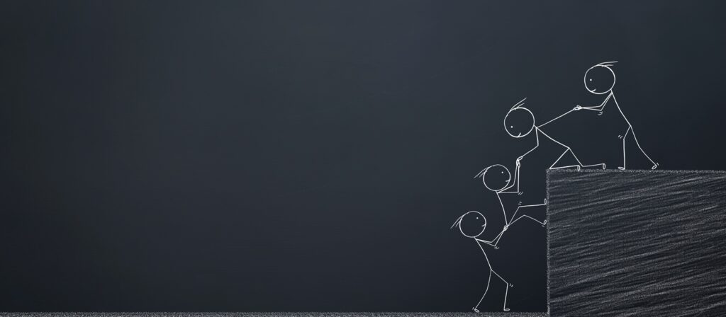 Chalk drawing of four stick figures helping each other climb over a ledge, symbolising teamwork and support, on a dark chalkboard background.