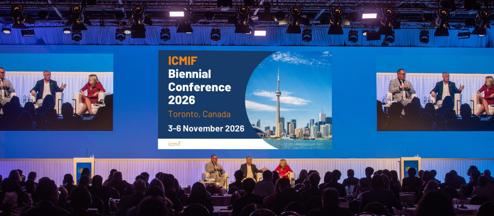 A conference panel with three people seated on stage in front of an audience. A large screen displays ICMIF Biennial Conference 2026, Toronto, Canada, 3–6 November 2026 with an image of Toronto’s skyline.