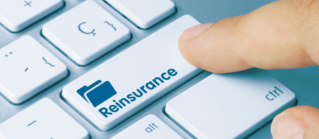 A finger presses a keyboard key labelled Reinsurance with a blue folder icon, suggesting the concept of reinsurance in a digital or online context.